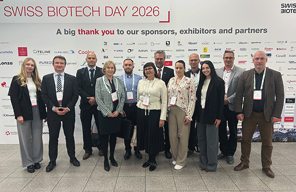 Slovenská podnikateľská delegácia na podujatí Swiss Biotech Day 2026 v Bazileji pózuje pred prezentačnou stenou s logami partnerov, vystavovateľov a sponzorov. Fotografia dokumentuje účasť slovenských MSP na podnikateľskej misii SARIO pri príležitosti podujatí Swiss Biotech Day a Eureka Global Innovation Summit 2026.